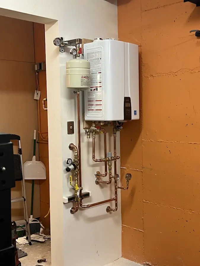 Plumbing technician inspecting water heater connections in Margate